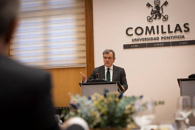 Un hombre habla en un podio durante un evento en la Universidad Pontificia Comillas.