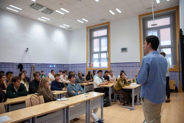 Un grupo de estudiantes escucha atentamente a un ponente en un aula.