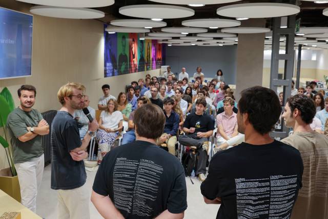 Un grupo de personas asisten a una charla o presentación en un entorno académico o profesional.