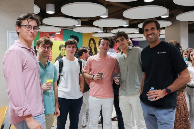 Un grupo de jóvenes posando en un evento social en un ambiente moderno.