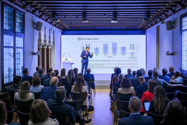 Un ponente está presentando información a un público en un evento profesional.
