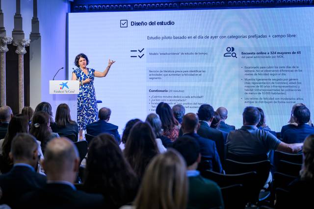 Una mujer presenta un estudio ante una audiencia en un evento profesional.