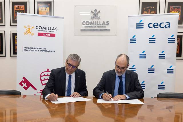 Dos hombres firmando un acuerdo en una mesa, con logos de instituciones en el fondo.