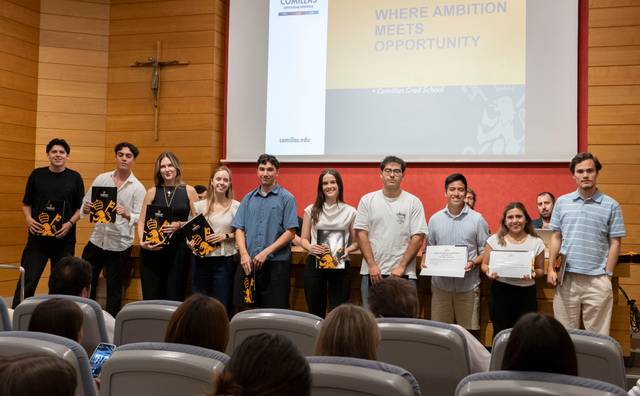 Un grupo de estudiantes celebra su logro en un evento académico mostrando sus certificados y premios.