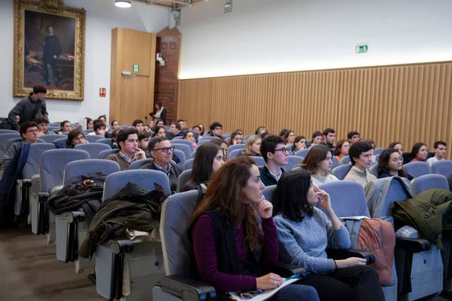 Una sala con una audiencia sentada durante una conferencia.