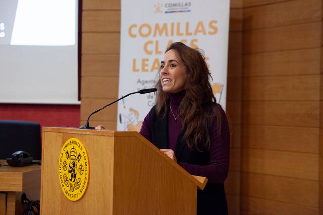 Una mujer habla desde un podio durante un evento en una universidad.