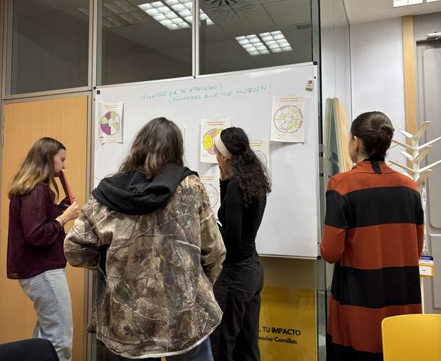 Un grupo de personas está trabajando juntas frente a una pizarra en una sala de reuniones.