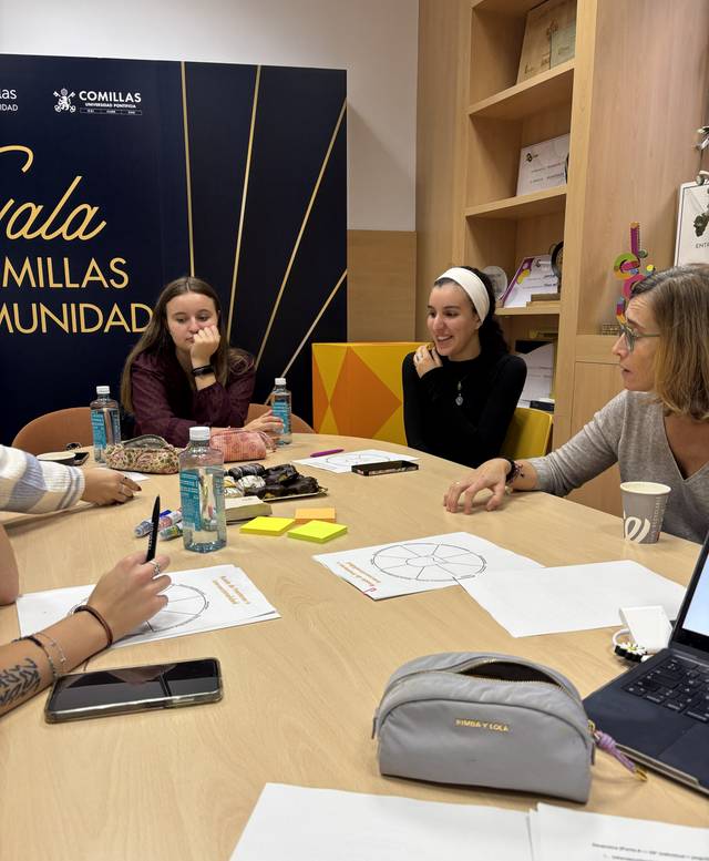 Un grupo de personas se reúne alrededor de una mesa, trabajando colaborativamente en un ambiente de estudio.