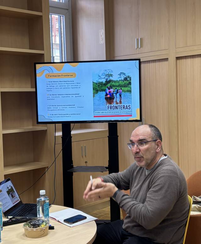 Un hombre está sentado frente a una pantalla que muestra información sobre un proyecto llamado 'Fronteras'.
