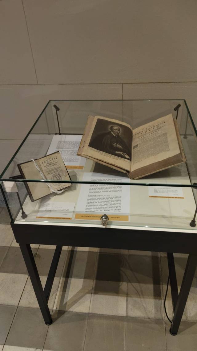 Una vitrina que muestra dos libros antiguos y documentos en un museo.