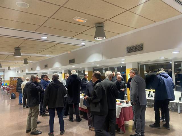Un grupo de hombres conversando y degustando comida en un ambiente social.