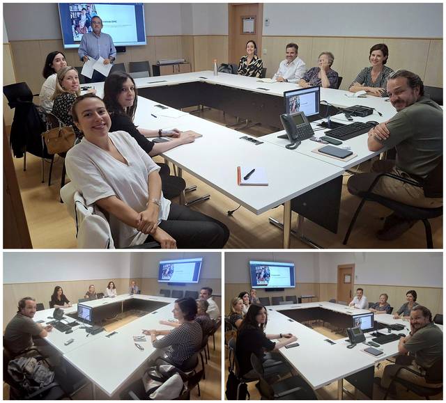 Reunión de un grupo de personas en una sala con mesas y computadoras.
