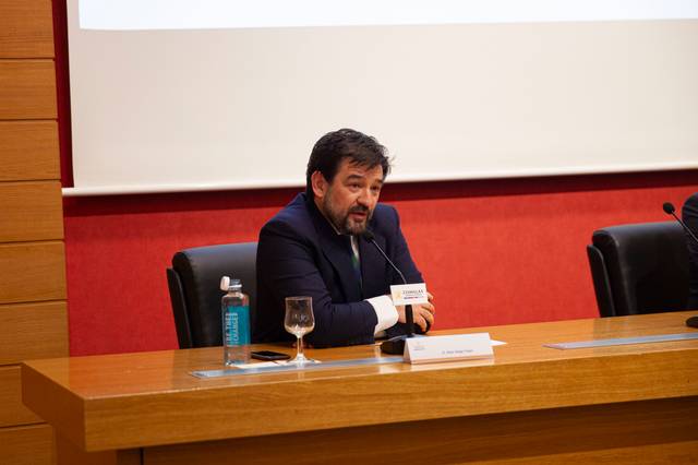 Un hombre hablando en un panel de conferencias.