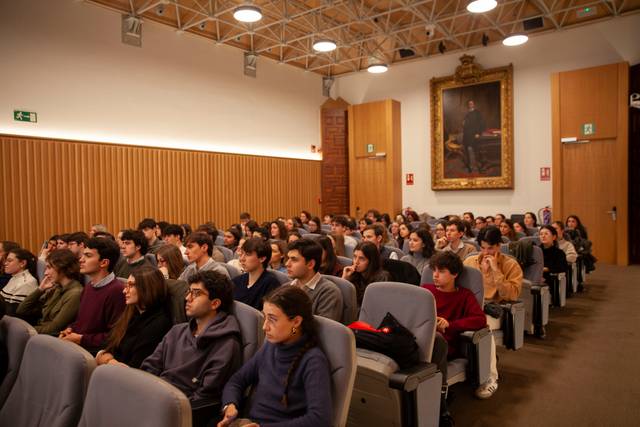 Un grupo de personas están sentadas en un auditorio atendiendo a un evento.