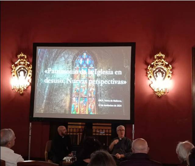 Personas sentadas en una sala, asistiendo a una presentación sobre el patrimonio de iglesias en desuso.