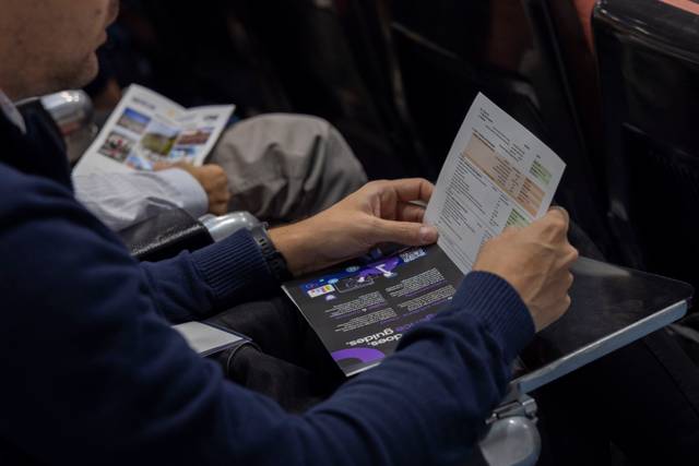 Una persona está observando documentos impresos mientras se sienta en un lugar público.