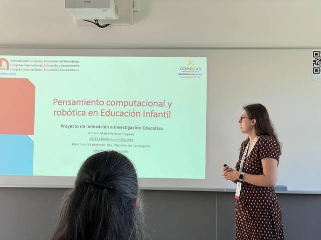 Una presentadora expone sobre pensamiento computacional y robótica en educación infantil en un congreso educativo.