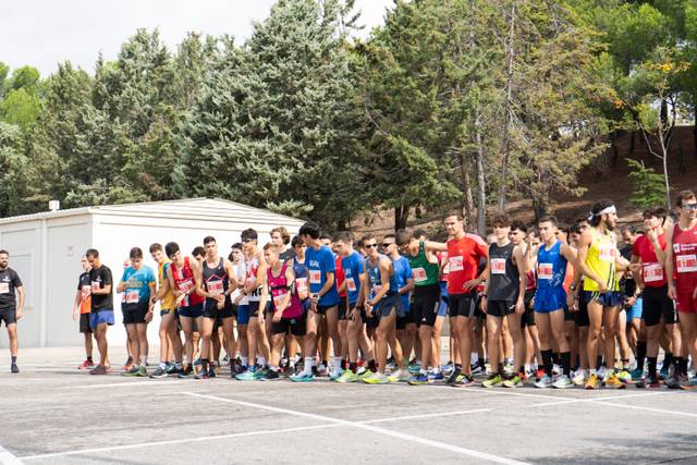 A group of runners is lined up at the starting line of a race, ready to start.