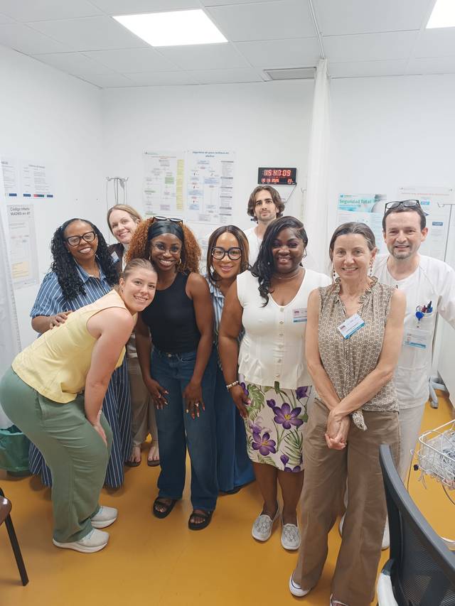 Un grupo de profesionales sonrientes se encuentran en una sala de trabajo.