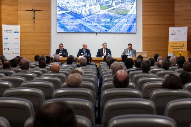 Un grupo de ponentes discute un tema importante en una sala llena de asistentes.