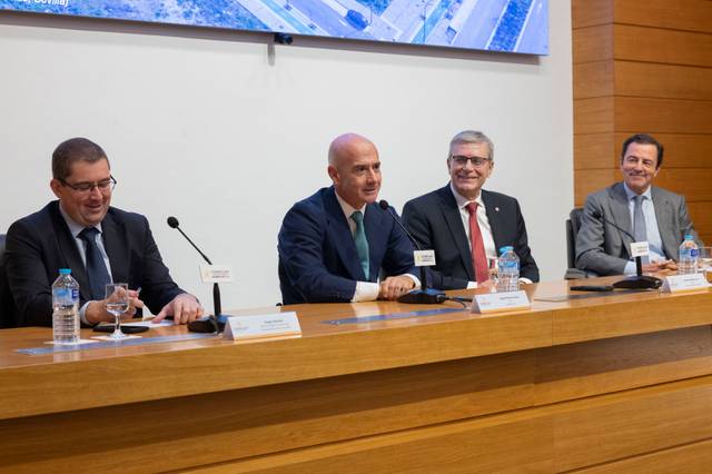 Cuatro hombres sentados en una mesa durante un evento formal.