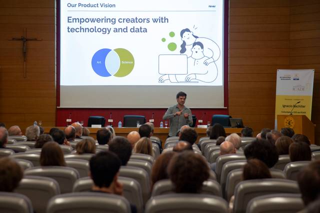 Un ponente presenta sobre tecnología y datos ante un auditorio lleno de personas.