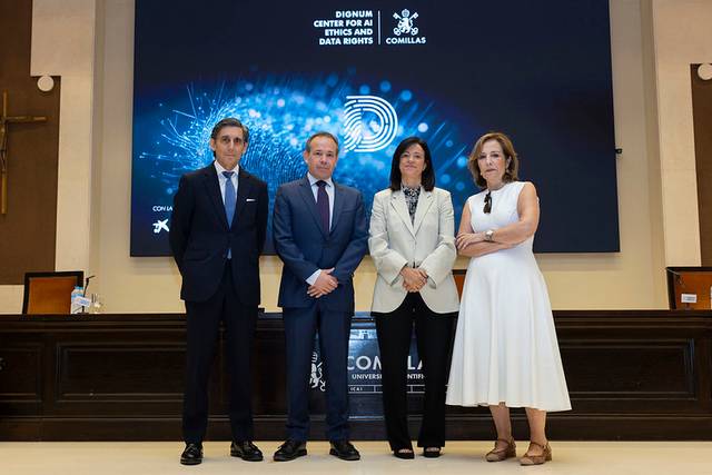 Cuatro personas posan en un evento oficial en un entorno académico.