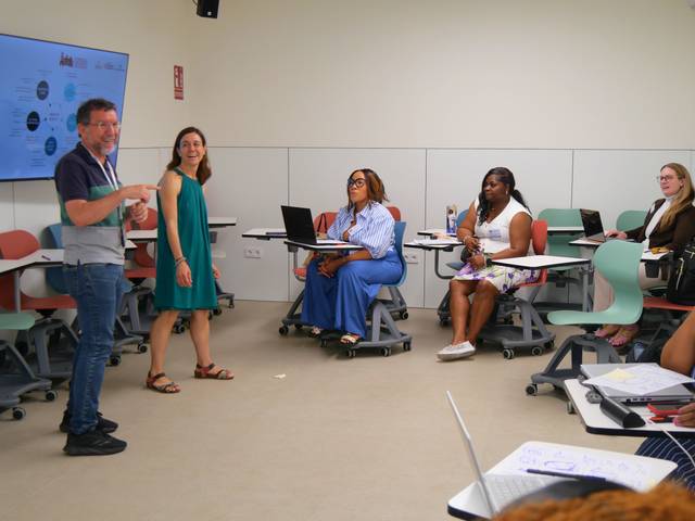 Un grupo de personas participa en una sesión interactiva en un aula moderna.