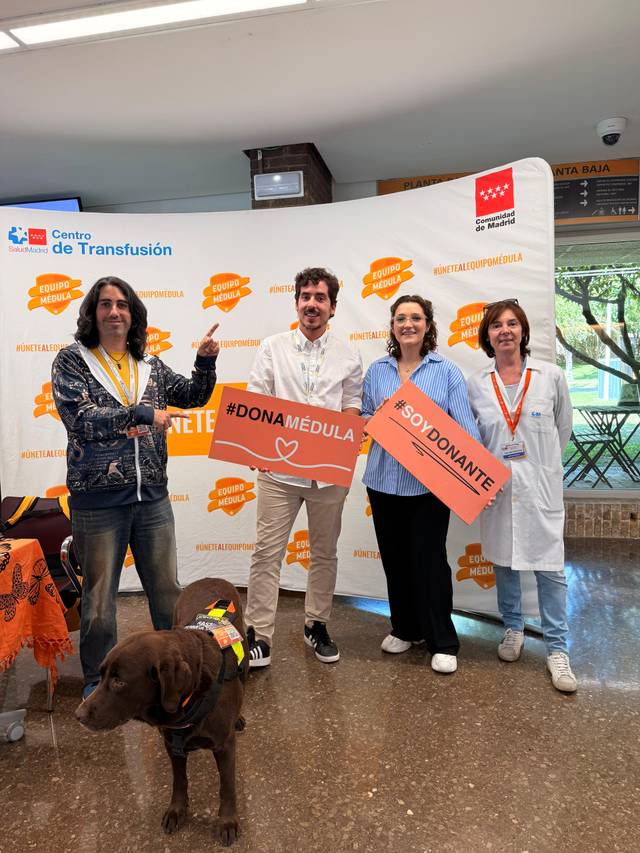 Un grupo de personas sostiene carteles sobre la donación de médula en un centro de transfusión.