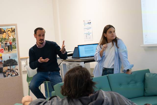 Una presentación en la que un hombre y una mujer conversan en un entorno académico.