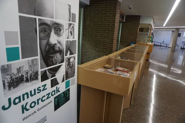 La imagen muestra una exposición sobre Janusz Korczak con una vitrina vacía y un panel informativo a un lado.