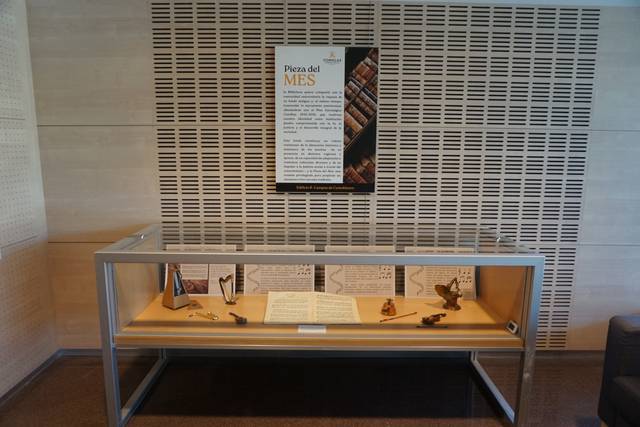 La imagen muestra una vitrina exhibiendo objetos y documentos en un entorno moderno.
