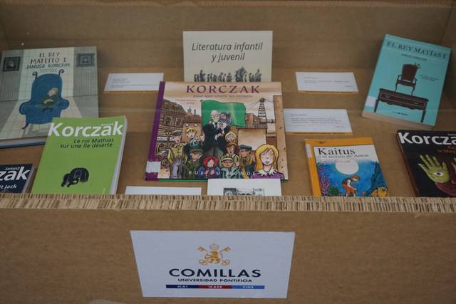Una exhibición de literatura infantil y juvenil con varios libros expuestos en una caja.