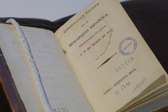 Imagen de un libro antiguo que contiene una constitución política de la monarquía española.