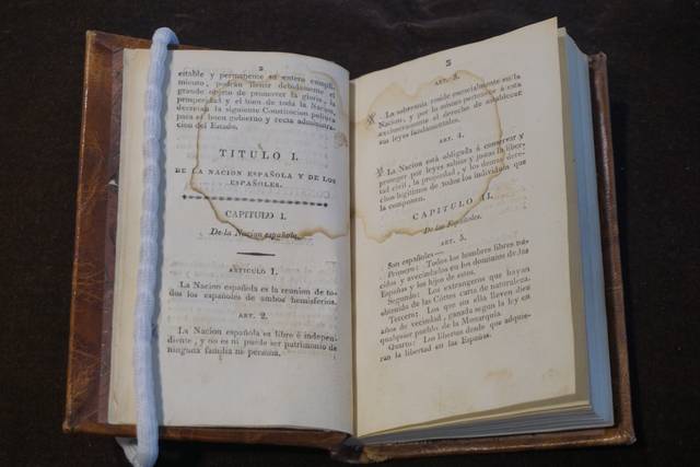 El libro abierto presenta textos en castellano con marcas de tiempo en las páginas.