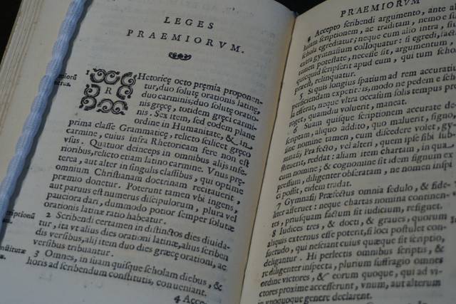 Un libro antiguo abierto que muestra texto impreso en páginas amarillentas.