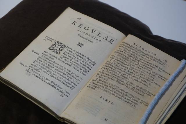 Un libro antiguo abierto con texto impreso en páginas amarillentas.