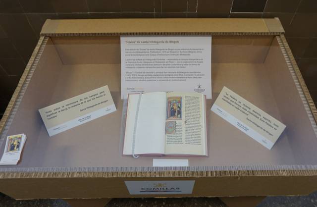 Exposición de un libro antiguo y varios documentos relacionados en una vitrina de cartón.