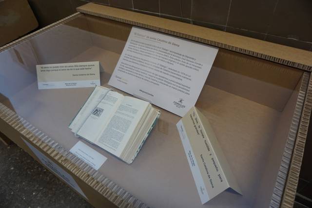 Una exposición que muestra un libro abierto en una vitrina junto a información relacionada.