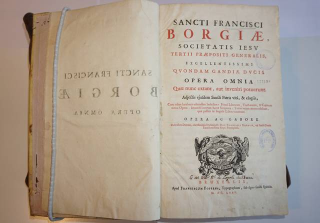 El libro abierto muestra una página con el título y la portada de una obra de San Francisco de Borja.
