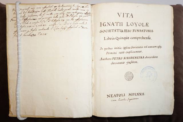 El libro abierto muestra la portada de 'Vita Ignatii Loyolæ', una obra sobre san Ignacio de Loyola, escrita en latín.