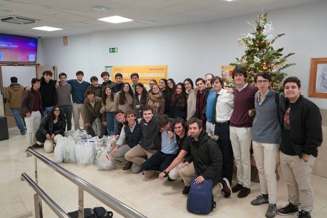 Un grupo de estudiantes posando juntos en un espacio público decorado para las fiestas.