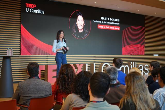 Una oradora en el escenario de un evento TEDx en U Comillas habla sobre un tema relacionado con su movimiento.