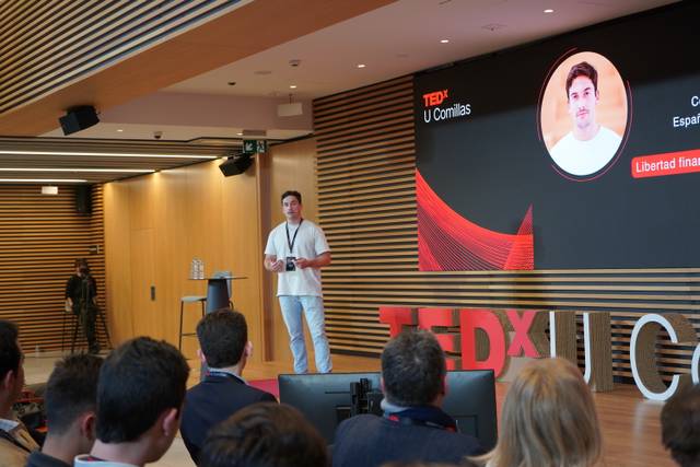 Un conferencista presenta en un evento TEDx en un auditorio moderno.