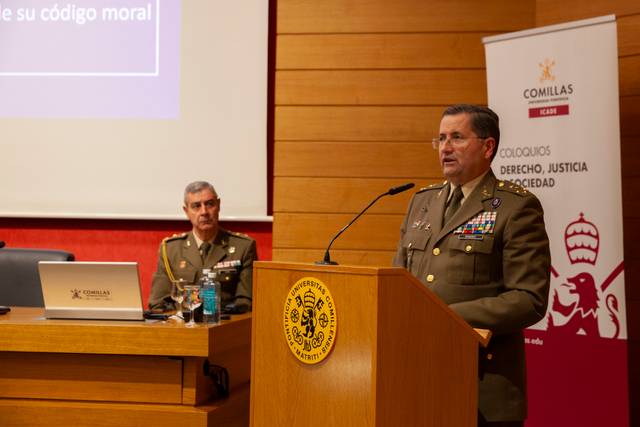 Un militar está hablando en un evento sobre derecho y justicia en presencia de otro oficial.