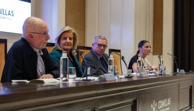 Cuatro personas sentadas en una mesa durante un panel de discusión en un evento, con micrófonos y botellas de agua frente a ellos.