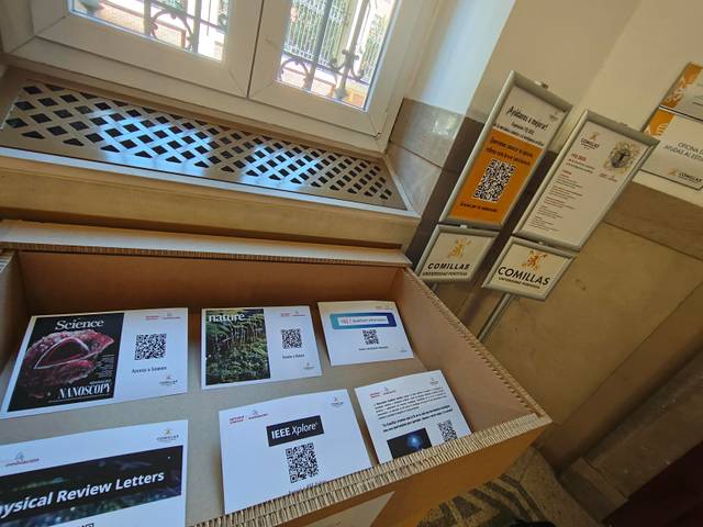 Una caja con revistas científicas y códigos QR en un entorno académico.