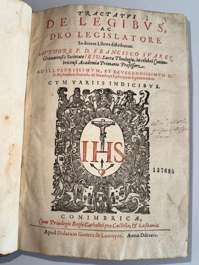 Este objeto es la portada de un tratado antiguo titulado 'De legibus, ac deo legislatore', con detalles elaborados y el monograma IHS.
