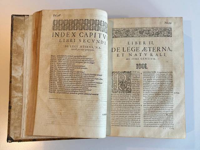 Un libro antiguo abierto que muestra páginas con texto y un índice de capítulos.