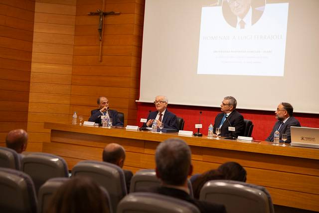 Un evento académico en el que varios panelistas discuten sobre el homenaje a Luigi Ferrajoli.